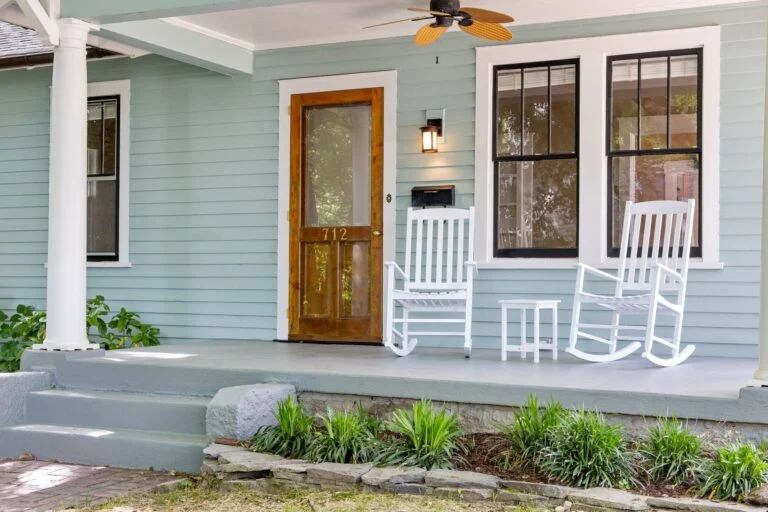 Front porch with rocking chairs and wood door