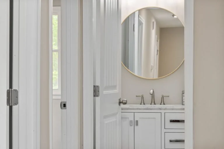 White bathroom with round mirror